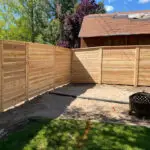 Cedar fence installation showing corner detail with fire pit in backyard - All Woods Tree Service