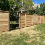 Cedar privacy fence with metal horizontal rail gate by All Woods Tree Service, Northern Utah fence installation